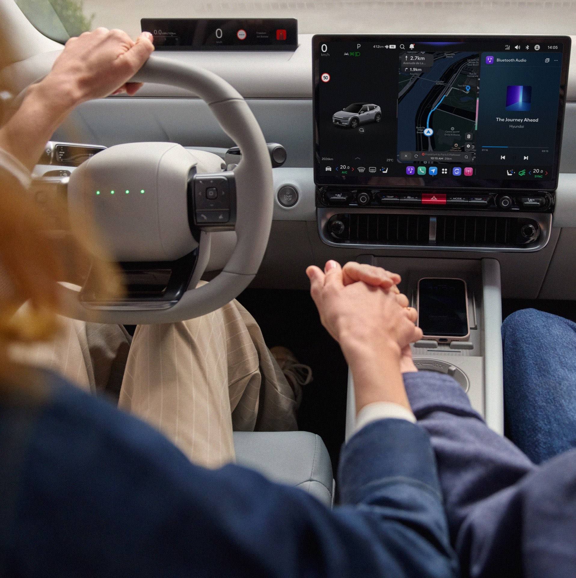 Close up of two people holding hands in front of the center touch screen of the Hyundai IONIQ 3.
