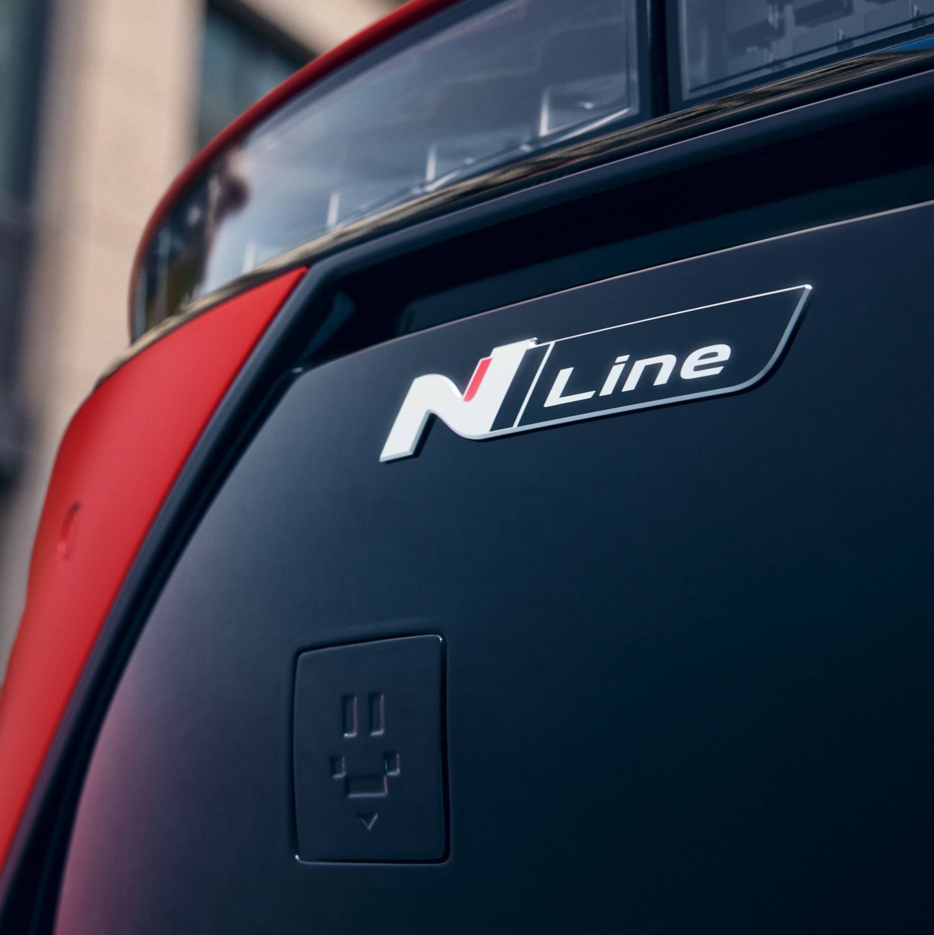 Close up image of the N Line badge on the front bumper of a red Hyundai IONIQ 3 N Line.