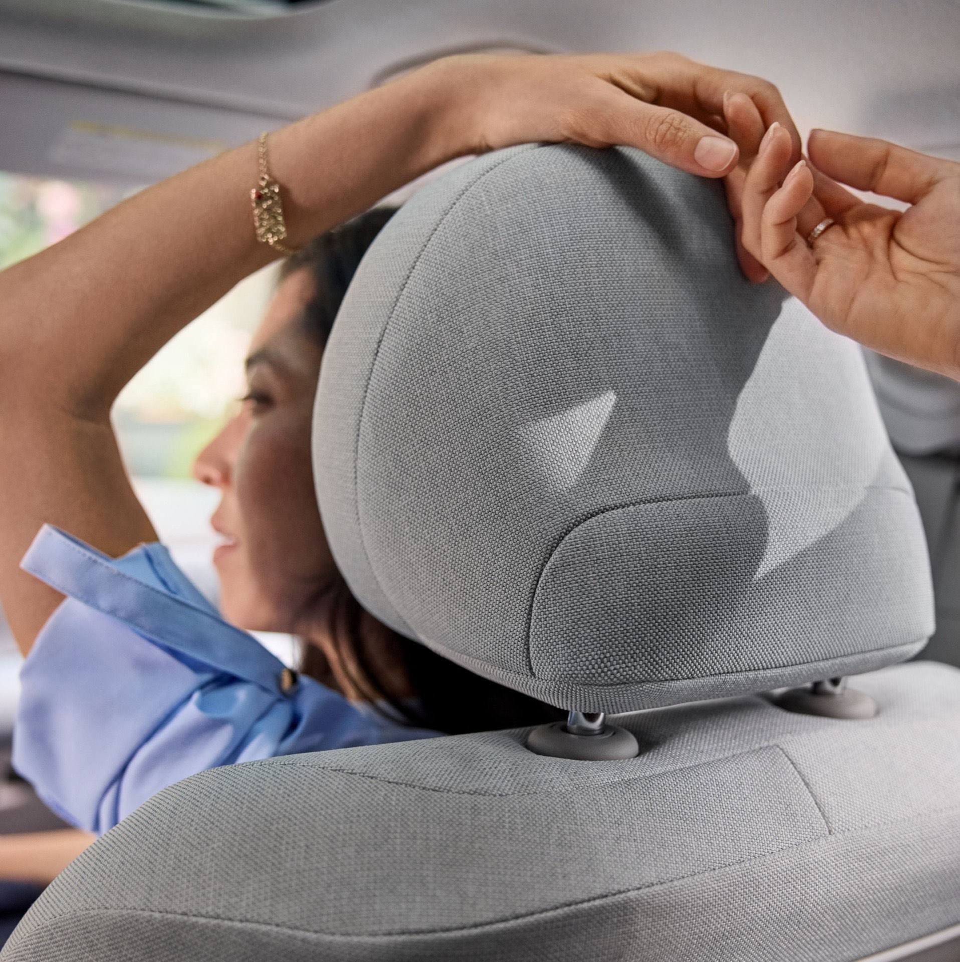 Close up of two people holding hands over the passenger seat headrest of the Hyundai IONIQ 3.
