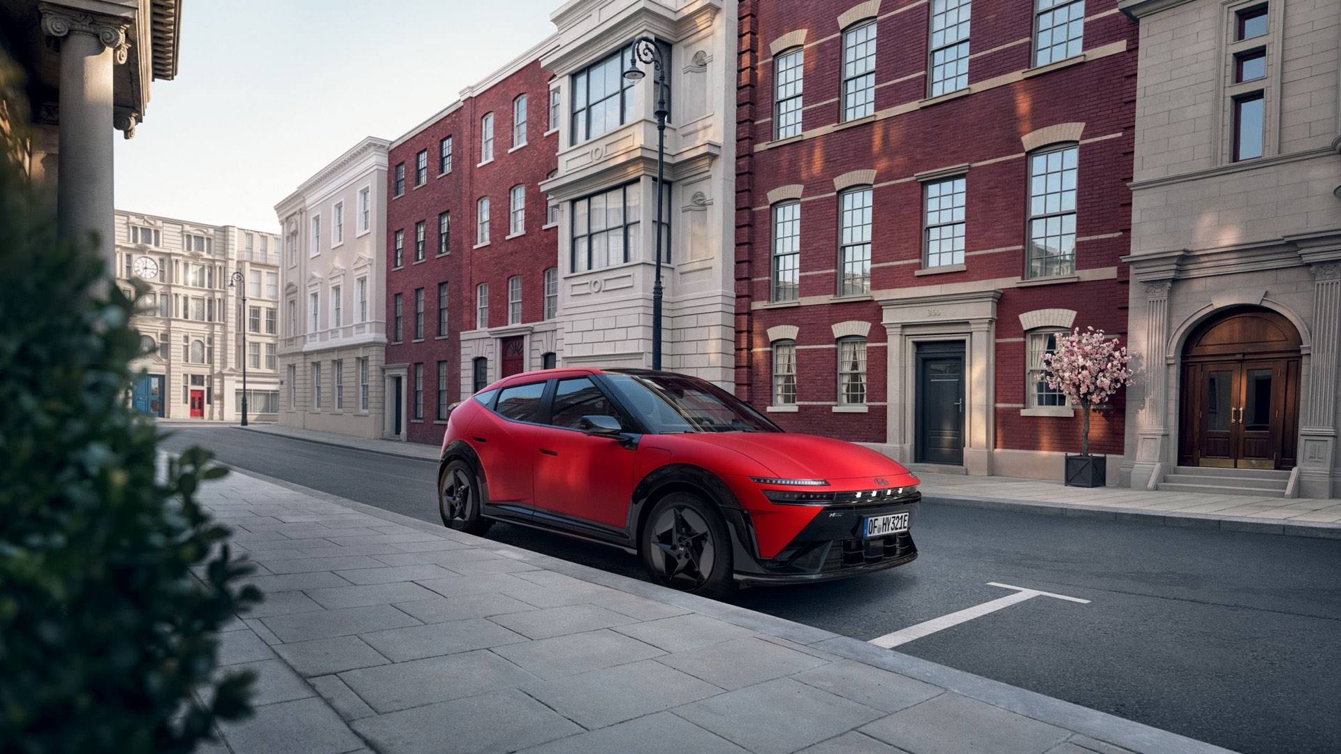 Red Hyundai IONIQ 3 N Line parked on a city street in front of attractive old buildings.