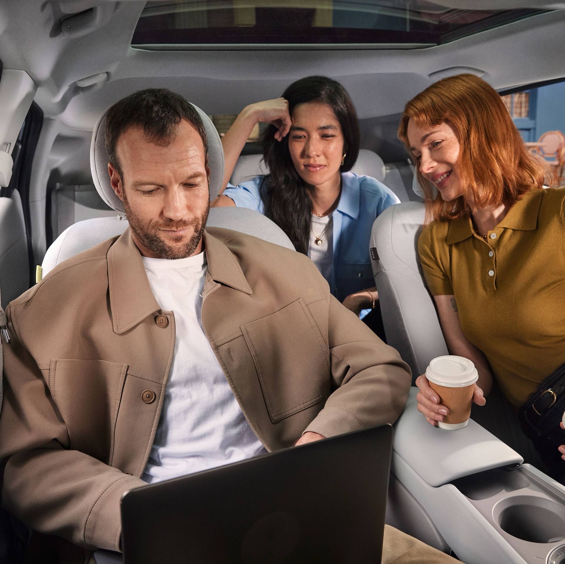 Three people sitting inside the&nbsp;Hyundai IONIQ 3, the man working on a laptop.