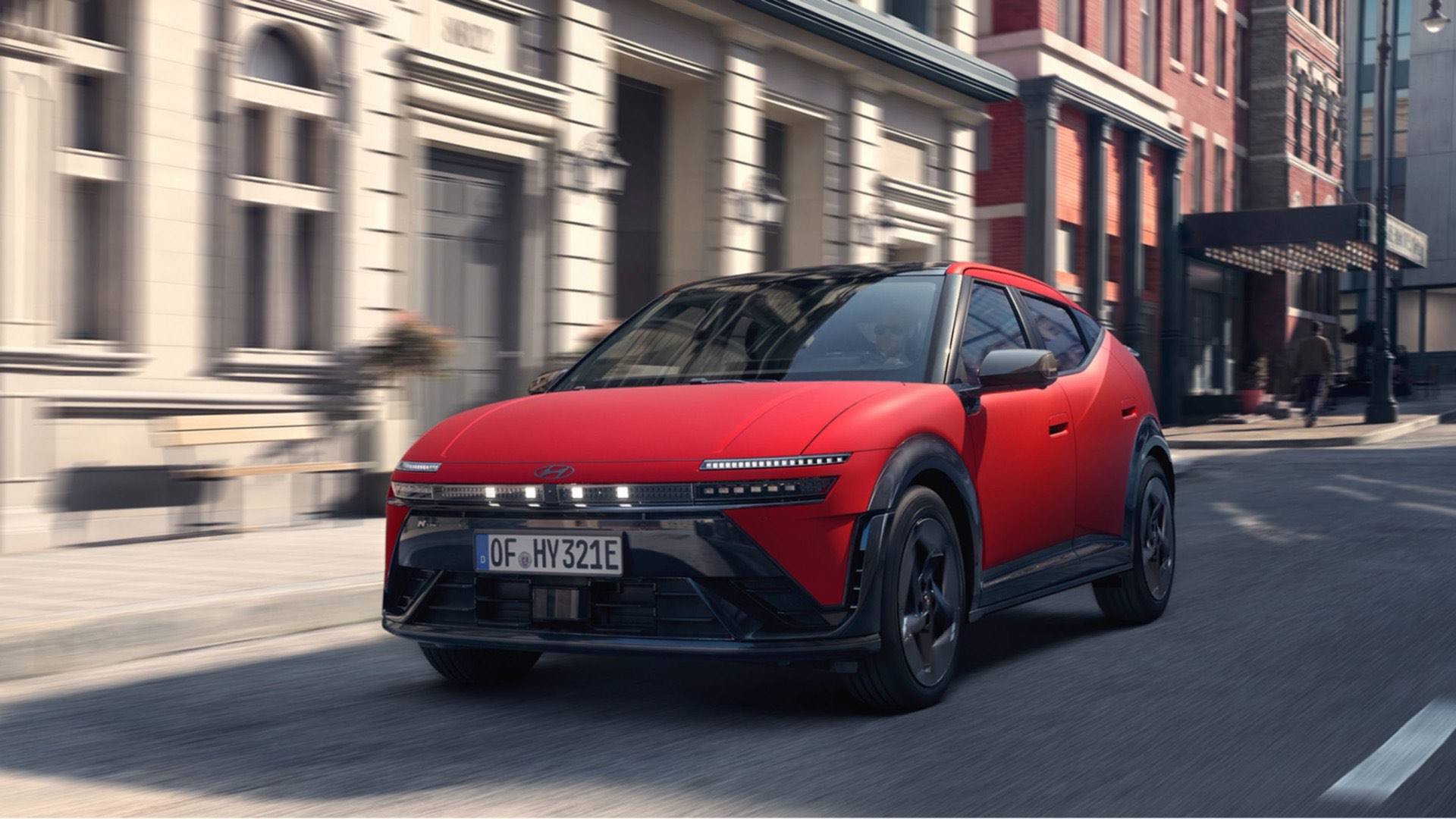 A Hyundai IONIQ 3 egy piros példánya városi utcán halad