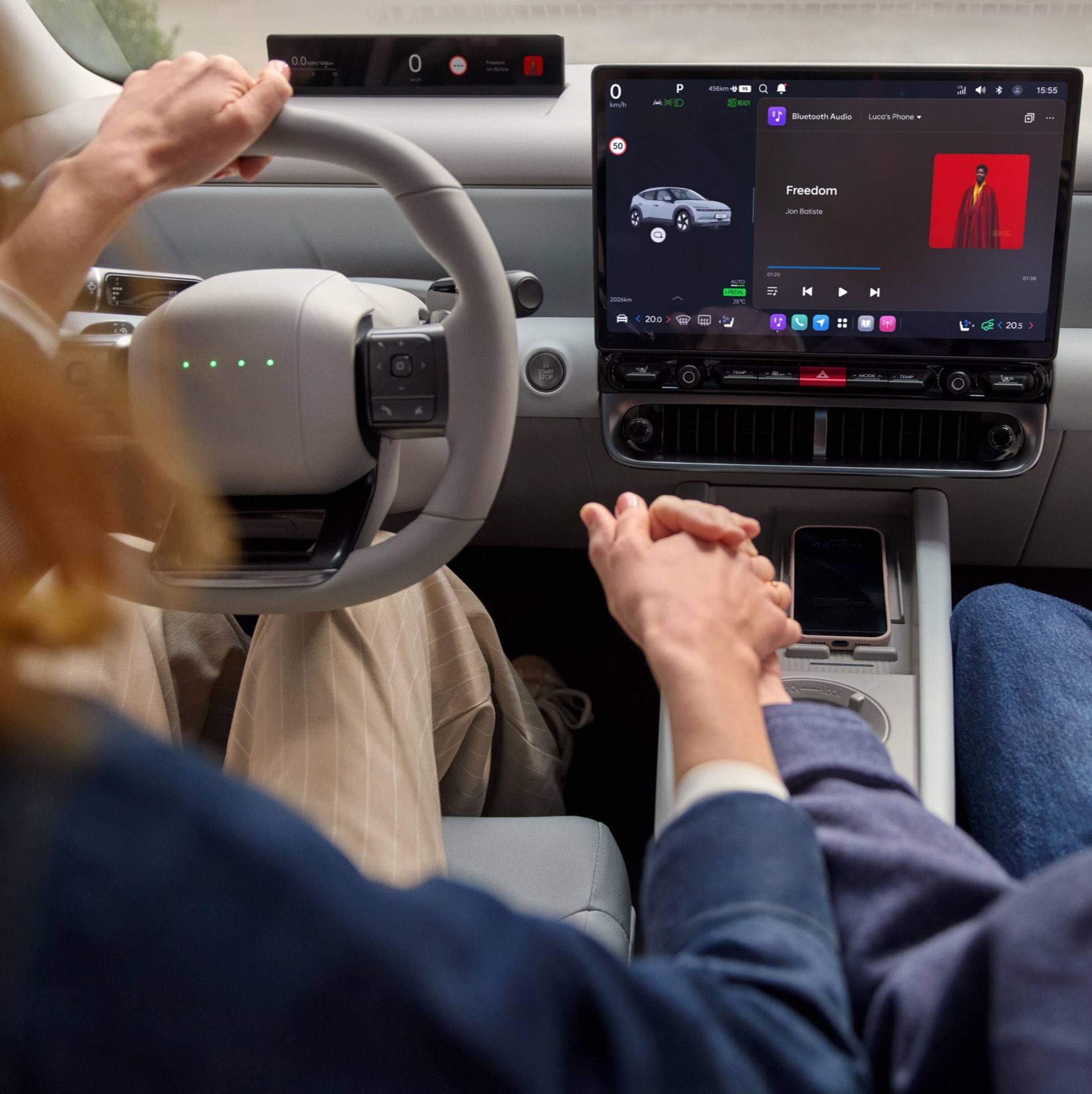 Close up of two people holding hands in front of the center touch screen of the Hyundai IONIQ 3.